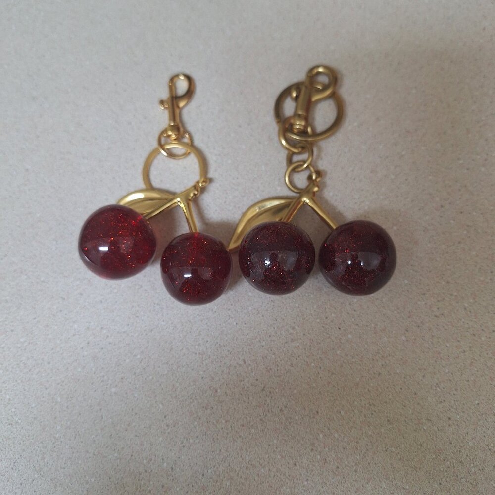 TWO HAND BAG CHARMS.